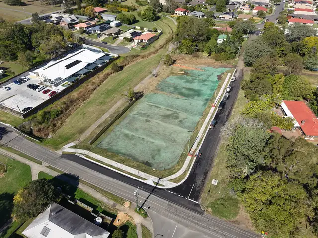 Aerial view of the finished Halletts Road subdivision in Redbank Plains, with new road seal, kerb and footpath.